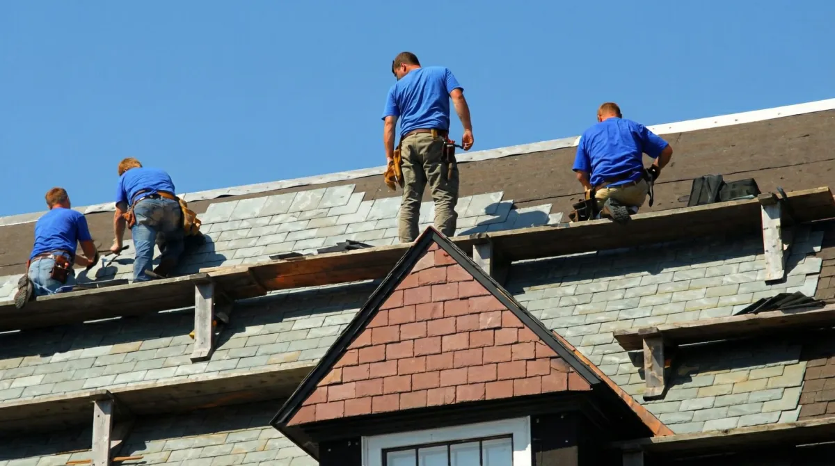 Roof replacement in progress with a team of professional contractors installing new shingles on a residential home in Phoenix, AZ
